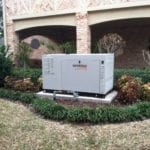 A large generac brand generator outside a home in a garden