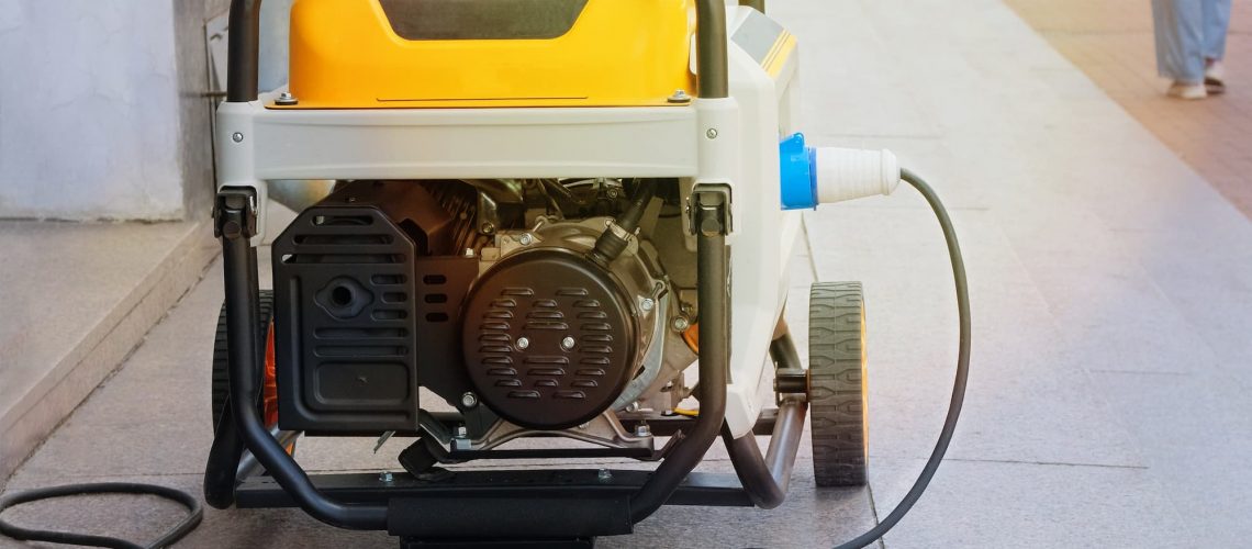 a small yellow generator on wheels plugged in to an outlet